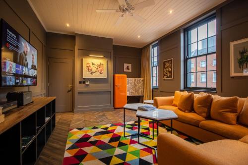 都柏林都柏林迪恩酒店的客厅配有沙发和色彩缤纷的地毯