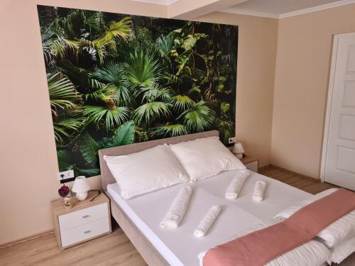 毛科Napfény Apartman的卧室配有一张白色床,墙上挂有绘画作品