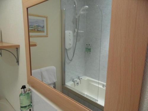 卡布里奇Cairn Hotel的带淋浴、浴缸和镜子的浴室