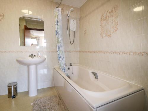 尤托克西特Summerfields的浴室配有盥洗盆、浴缸和盥洗盆