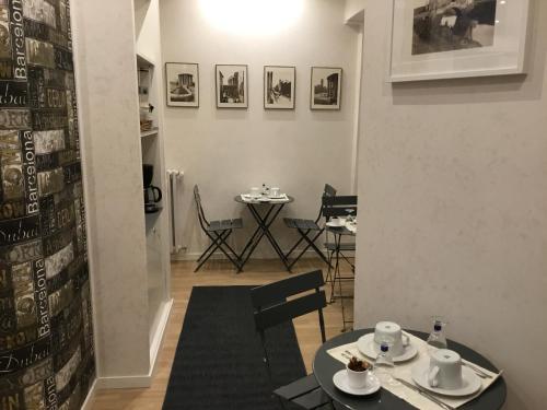 罗马LE FATE SUITES的用餐室配有2张桌子和1张桌子及椅子