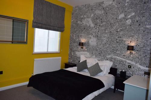 伦敦The Fitzrovia Belle Hotel的一间卧室设有一张床和砖墙