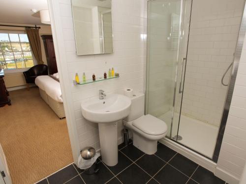 韦斯特贝The George的浴室配有卫生间、盥洗盆和淋浴。