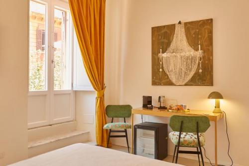 罗马Ripagrande a Trastevere的客房设有书桌、两把椅子和窗户。