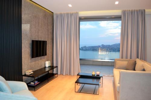 萨兰达ArtNest Luxury Hotel & Suites的带沙发和大窗户的客厅