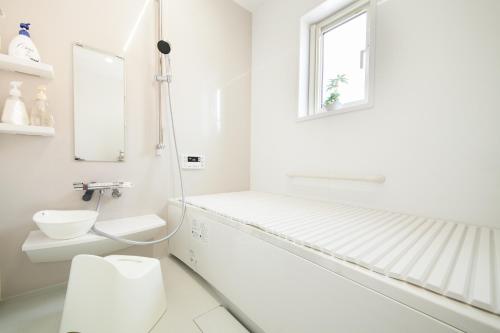 那须盐原市那須塩原にある貸別荘 レンガの家Ｓｏｒａ的白色的浴室设有卫生间和窗户。
