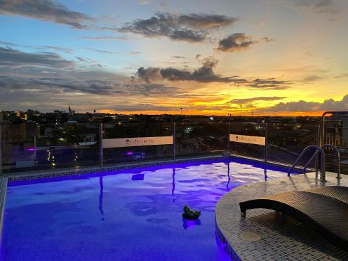 伊基托斯Nativo Hotel的一座享有日落美景的建筑的顶部游泳池