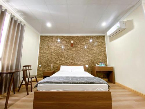 海防Đình Vũ 3 Motel的卧室配有一张床铺,位于带墙壁的房间