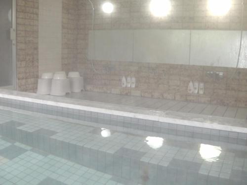 白马村雷鸟朋友酒店的一间带镜子和游泳池的浴室