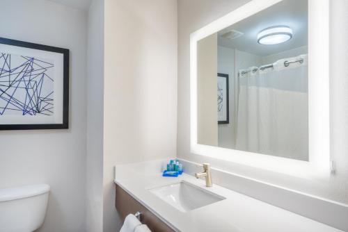 法兰克福法兰克福智选假日套房酒店的白色的浴室设有水槽和镜子