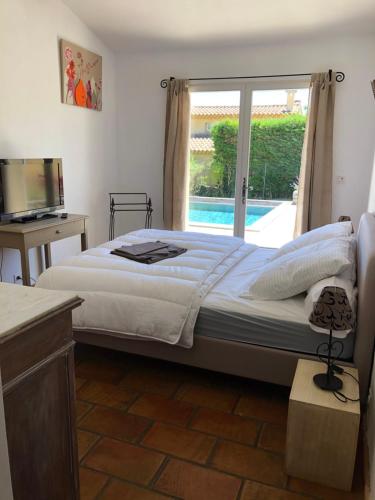 洛里Villa dans le LUBERON à 2 km de LOURMARIN的一间卧室设有一张大床和一个窗户。