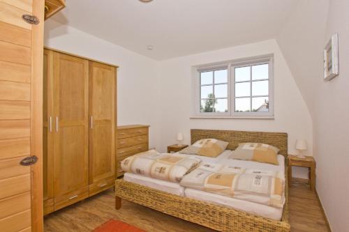 吕根岛上的维克Ostseehaus Odin Doppelhaushälfte的一间卧室设有一张大床和一个窗户。