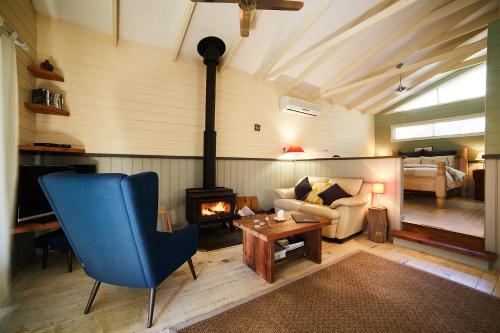 Bilpin质朴精神木屋的客厅设有蓝椅和壁炉