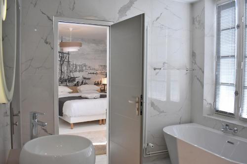 迪耶普Villa Castel Chambres d'hôtes B&B的白色的浴室设有浴缸和水槽。