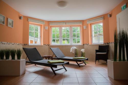 菲尔斯滕贝格英博格维拉旅馆的一间设有两把椅子和窗户的等候室