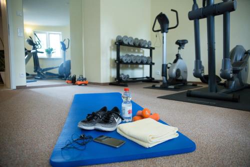 菲尔斯滕贝格英博格维拉旅馆的健身房配有带鞋的蓝色垫子和一瓶水