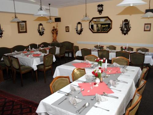 维尔施涅多夫沃德斯伍旅馆的一间用餐室,配有白色的桌椅和红色的餐巾
