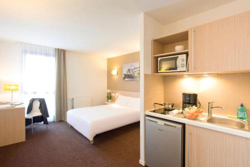 勒阿弗尔勒阿弗尔码头阿德吉奥阿克瑟斯公寓式酒店的酒店客房设有白色的床和厨房