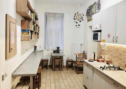 利沃夫Etno Hostel的厨房配有白色橱柜和桌子