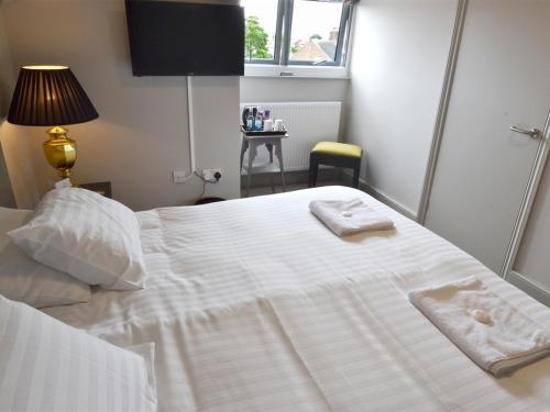 布里奇诺斯Woodberry Inn的卧室配有白色床和毛巾