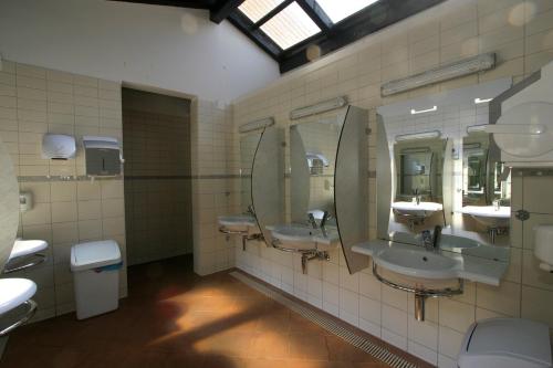 罗维尼Easyatent Safari tent Polari的配有3个盥洗盆和镜子的公共浴室