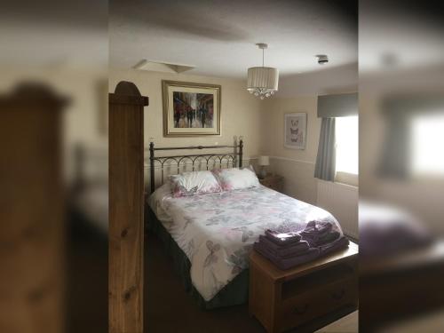 艾恩布里奇Ye Olde Robin Hood Inn的卧室两张照片,配有一张床