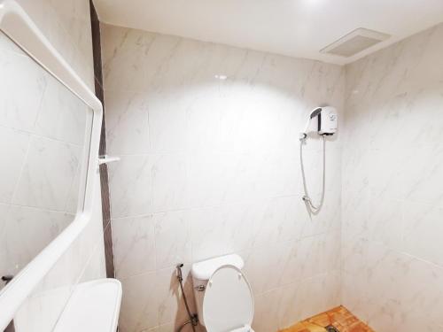 梭桃邑ลิตเติ้ล ฮิลล์ สัตหีบ รีสอร์ท ( Little Hill Sattahip Resort )的白色的浴室设有卫生间和淋浴。