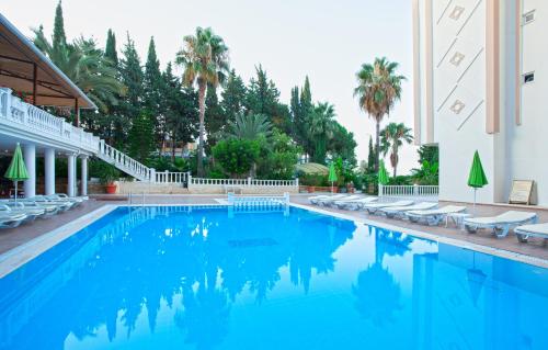 阿萨拉尔Ramira Beach Hotel - All Inclusive的一座带躺椅的游泳池和一座建筑