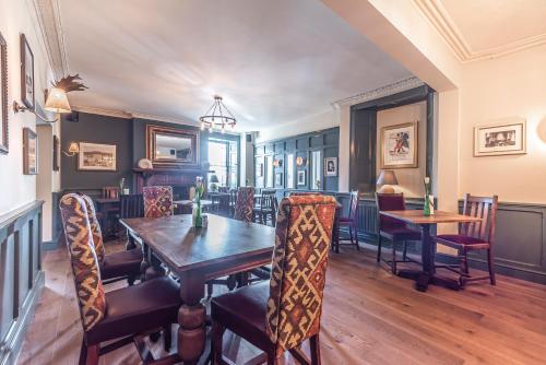 Bishopsteignton考克哈文阿姆斯宾馆的一间带木桌和椅子的用餐室