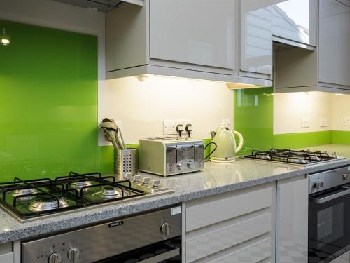 朴次茅斯Blue Star House的绿色厨房配有炉灶和微波炉