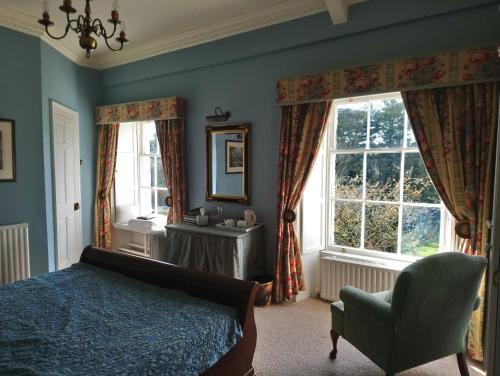 新罗斯Kilmokea Country Manor & Gardens的卧室配有床、椅子和窗户。
