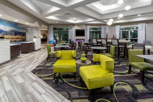 路易维尔路易斯维尔丹佛博尔德拉昆塔套房酒店的一间设有黄色椅子和桌子的等候室