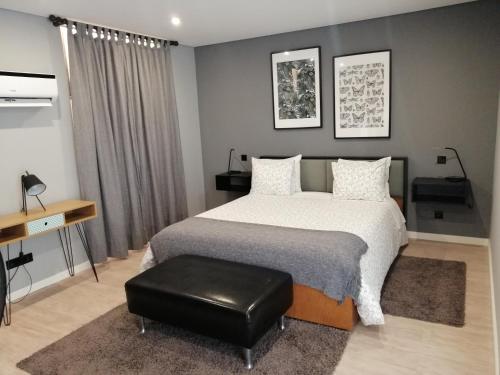 波尔图波尔图侯爵套房旅馆的一间卧室配有一张床和一个黑色凳子