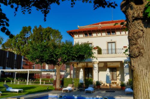 阿莱利亚阿雷阿勒拉酒店的一座建筑前面设有游泳池