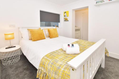克鲁Townhouse @ Henry Street Crewe的卧室配有一张带黄色枕头的大型白色床。