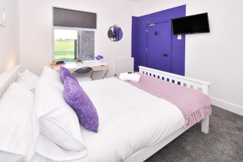 克鲁Townhouse @ Henry Street Crewe的卧室配有白色床和紫色枕头