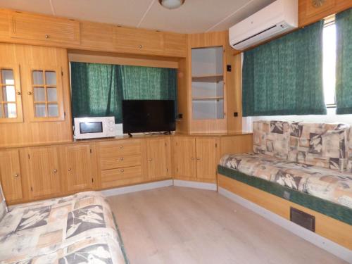 苏埃卡Camping Barraquetes的客房设有两张床和一台平面电视。