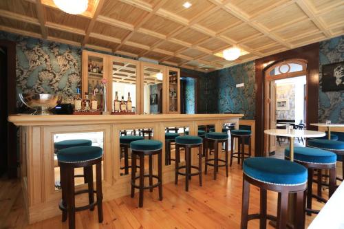 里斯本圣地亚哥阿尔法玛 - 精品酒店的一间设有蓝色凳子的餐厅内的酒吧