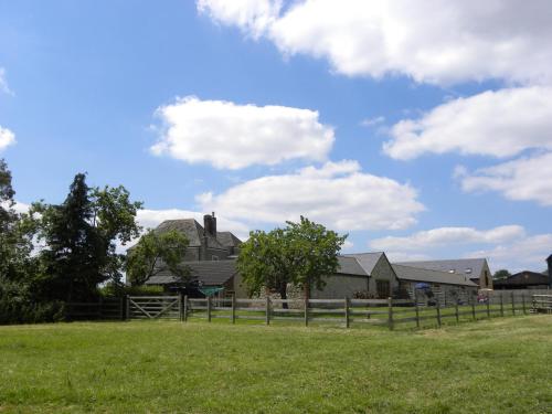皇家伍顿巴西特Hook Farm Cottages的围栏田野中的房屋