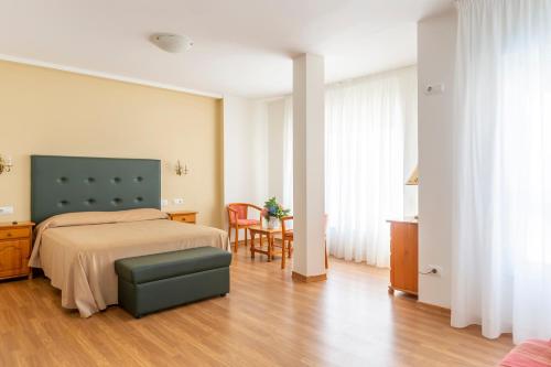 拉科萨诺迪鲁斯酒店的卧室配有一张床和一张桌子及椅子