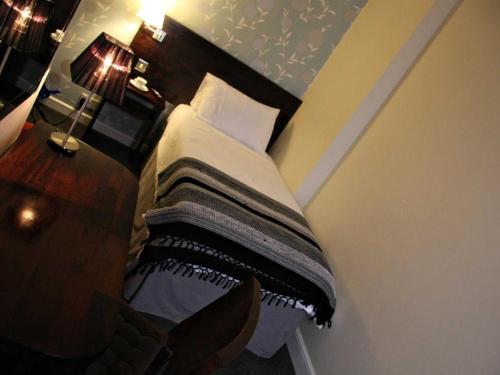 诺里奇Hotel Belmonte的一间卧室配有一张带木制床头板的床