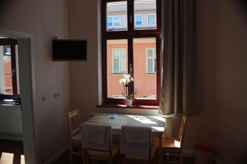 菲尔斯滕贝格Gästehaus INNFernow的一张餐桌,窗户上放着花瓶