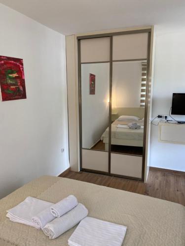 布德瓦Apartments Boss的卧室配有镜子和床上的2条毛巾
