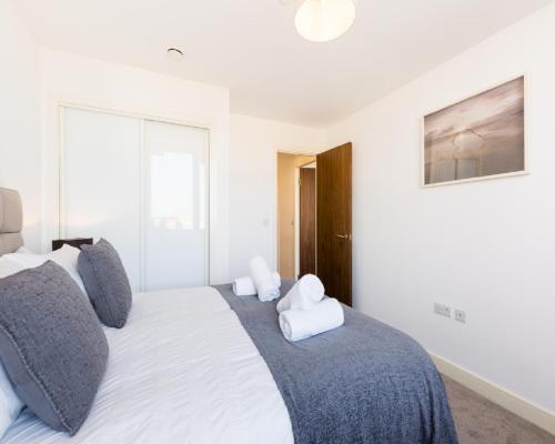 伯明翰KCS Luxury Apartment - Broad Street Birmingham的卧室配有带灰色枕头的大型白色床