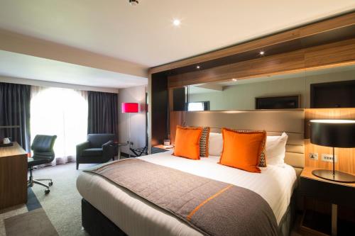 比肯斯菲尔德凯恩贝尔豪斯酒店的酒店客房配有一张带橙色枕头的大床