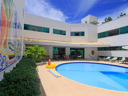 萨尔瓦多伊塔普瓦海滩灯塔酒店的一座带游泳池的大型白色房屋