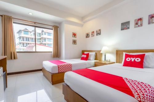 清迈Super OYO 1096 Winner Inn Hotel的两张位于酒店客房的床,配有红色和白色枕头