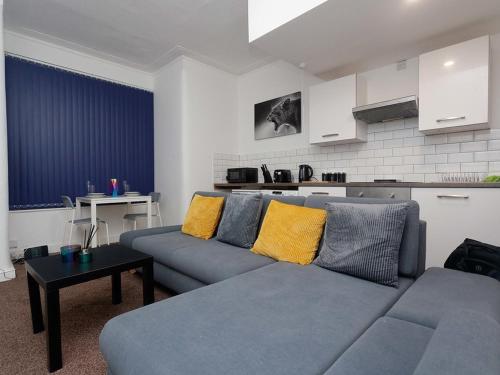 利兹Kirkstall House的客厅配有蓝色的沙发和黄色的枕头。