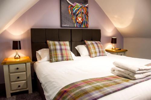 MacduffThe Knowes Hotel & Restaurant的一间卧室配有一张床和两张带台灯的桌子。