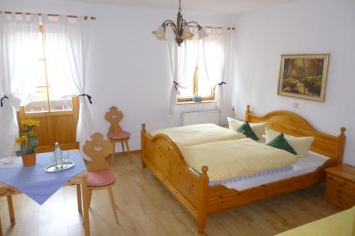 EurasburgLandgasthof Berg的卧室配有床、桌子和窗户。